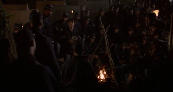 Movie still from “Glory” (1989), directed by Edward Zwick – A group of people sitting around a fire; Wide shot, High angle