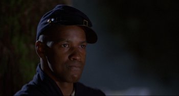 Movie still from “Glory” (1989), directed by Edward Zwick – A man wearing a hat and looking at the camera; Close Up shot, Low angle