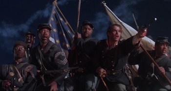 Movie still from “Glory” (1989), directed by Edward Zwick – A group of men in uniforms holding flags; Medium shot, Low angle