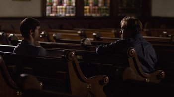 Movie still from “God's Not Dead” (2014), directed by Harold Cronk – Two people sitting in a church pews talking to each other; Wide shot, Over the shoulder angle