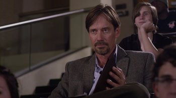 Movie still from “God's Not Dead” (2014), directed by Harold Cronk – A person wearing a suit and tie; Close Up shot, Over the shoulder angle