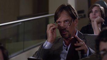 Movie still from “God's Not Dead” (2014), directed by Harold Cronk – A man in a suit holding his glasses up to his face; Close Up shot, Over the shoulder angle