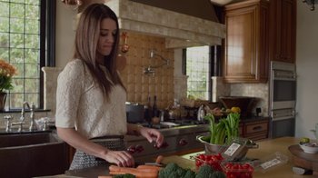 Movie still from “God's Not Dead” (2014), directed by Harold Cronk – A woman cutting carrots in a kitchen with other vegetables; Medium shot, Over the shoulder angle
