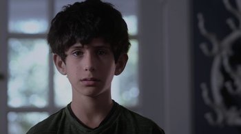 Movie still from “God's Not Dead” (2014), directed by Harold Cronk – A young boy is looking into the camera; Close Up shot, Over the shoulder angle