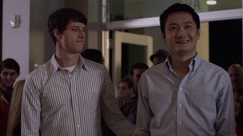 Movie still from “God's Not Dead” (2014), directed by Harold Cronk – Two young men holding hands while standing next to each other; Medium shot, Over the shoulder angle