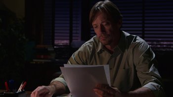 Movie still from “God's Not Dead” (2014), directed by Harold Cronk – A man sitting at a table looking at papers; Close Up shot, High angle