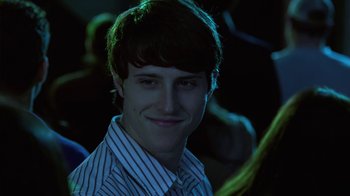 Movie still from “God's Not Dead” (2014), directed by Harold Cronk – A young man smiling for the camera at a party; Close Up shot, Over the shoulder angle