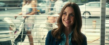 Movie still from “How to Be Single” (2016), directed by Christian Ditter – A beautiful young lady standing in front of a window; Close Up shot, Over the shoulder angle