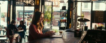 Movie still from “How to Be Single” (2016), directed by Christian Ditter – A woman sitting in front of a laptop computer; Medium shot, Over the shoulder angle