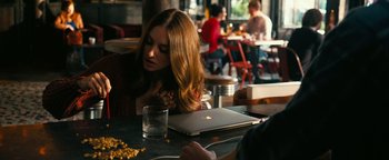 Movie still from “How to Be Single” (2016), directed by Christian Ditter – A woman sitting in front of an open laptop computer on top of a table; Medium shot, Over the shoulder angle