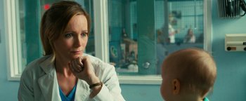 Movie still from “How to Be Single” (2016), directed by Christian Ditter – A woman wearing a white lab coat is sitting in front of a window; Close Up shot, Over the shoulder angle