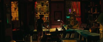 Movie still from “How to Be Single” (2016), directed by Christian Ditter – A woman standing in front of a desk in a dark room; Wide shot, High angle
