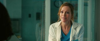 Movie still from “How to Be Single” (2016), directed by Christian Ditter – A woman wearing a white lab coat sitting in front of a window; Close Up shot, Over the shoulder angle