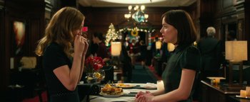 Movie still from “How to Be Single” (2016), directed by Christian Ditter – Two women sitting at a table in front of a christmas tree; Medium shot, Over the shoulder angle