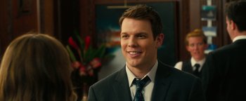 Movie still from “How to Be Single” (2016), directed by Christian Ditter – A man wearing a suit and tie smiling for the camera; Close Up shot, Over the shoulder angle