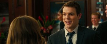 Movie still from “How to Be Single” (2016), directed by Christian Ditter – A man in a suit and tie smiling at the camera; Close Up shot, Over the shoulder angle