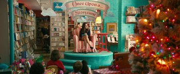 Movie still from “How to Be Single” (2016), directed by Christian Ditter – A woman sitting in a chair in a library; Wide shot, Over the shoulder angle