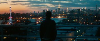 Movie still from “How to Be Single” (2016), directed by Christian Ditter – A man looking out over a city at night; Wide shot, Over the shoulder angle