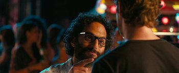 Movie still from “How to Be Single” (2016), directed by Christian Ditter – A man with a beard wearing glasses and a white shirt; Close Up shot, Over the shoulder angle