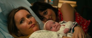 Movie still from “How to Be Single” (2016), directed by Christian Ditter – Two women and a baby laying in a bed; Close Up shot, High angle