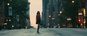 Movie still from “How to Be Single” (2016), directed by Christian Ditter – A woman walking down the street at dusk; Extreme Wide shot, Low angle