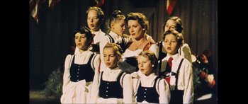 Movie still from “Goodnight Mommy” (2014), directed by Severin Fiala – A group of young children singing in front of an older woman; Medium shot, Low angle