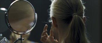 Movie still from “Goodnight Mommy” (2014), directed by Severin Fiala – A woman with her hand to her face in front of a mirror; Extreme Close Up shot, Over the shoulder angle