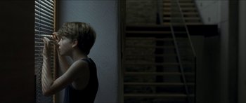 Movie still from “Goodnight Mommy” (2014), directed by Severin Fiala – A young boy standing in front of a staircase; Medium shot, Over the shoulder angle