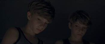 Movie still from “Goodnight Mommy” (2014), directed by Severin Fiala – Two young boys standing next to each other in the dark; Close Up shot, High angle