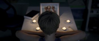 Movie still from “Goodnight Mommy” (2014), directed by Severin Fiala – A woman sitting in front of a mirror with candles; Medium shot, High angle