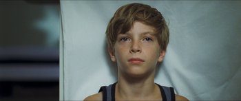 Movie still from “Goodnight Mommy” (2014), directed by Severin Fiala – A young boy is looking into the camera; Close Up shot, Overhead angle