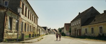 Movie still from “Goodnight Mommy” (2014), directed by Severin Fiala – Two people walking down a street in a village; Extreme Wide shot, Low angle