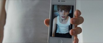 Movie still from “Goodnight Mommy” (2014), directed by Severin Fiala – A person holding up a cell phone with a picture of a boy; Close Up shot, High angle