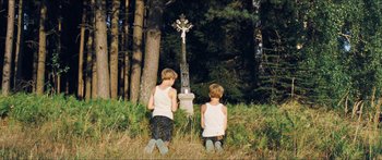 Movie still from “Goodnight Mommy” (2014), directed by Severin Fiala – Two young boys are looking at a cross in the woods; Wide shot, High angle