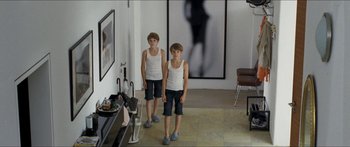 Movie still from “Goodnight Mommy” (2014), directed by Severin Fiala – Two young boys standing in front of a picture of a woman; Wide shot, High angle