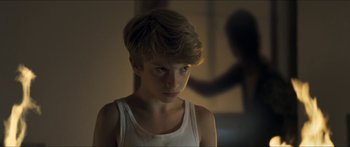 Movie still from “Goodnight Mommy” (2014), directed by Severin Fiala – A young boy in a white tank top looking at the camera; Close Up shot, Over the shoulder angle
