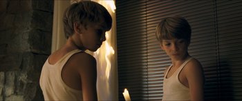 Movie still from “Goodnight Mommy” (2014), directed by Severin Fiala – Two young boys standing next to each other in front of a window; Medium shot, Over the shoulder angle
