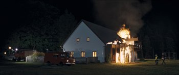 Movie still from “Goodnight Mommy” (2014), directed by Severin Fiala – A fire truck is parked in front of a burning house at night; Extreme Wide shot, Low angle