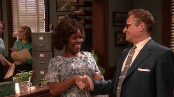 Movie still from “Grease Live!” (2016), directed by Thomas Kail – A woman and a man shaking hands in an office setting; Medium shot, Over the shoulder angle