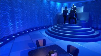 Movie still from “Grease Live!” (2016), directed by Thomas Kail – Three men are sitting on a set of stairs; Extreme Wide shot, High angle