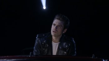 Movie still from “Grease Live!” (2016), directed by Thomas Kail – A man in a leather jacket looking up at the sky; Medium shot, Low angle