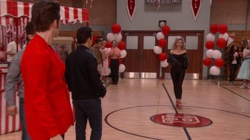 Movie still from “Grease Live!” (2016), directed by Thomas Kail – A group of people standing in front of a crowd; Wide shot, Over the shoulder angle