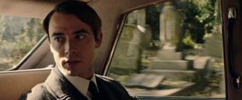 Movie still from “Greed” (2019), directed by Michael Winterbottom – A man in a suit sitting in the back of a car; Close Up shot, Over the shoulder angle