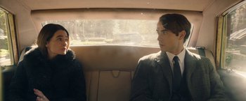 Movie still from “Greed” (2019), directed by Michael Winterbottom – A man and a woman sitting in the back of a car; Medium shot, Over the shoulder angle