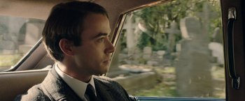 Movie still from “Greed” (2019), directed by Michael Winterbottom – A man sitting in the back of a car looking out the window; Close Up shot, Over the shoulder angle