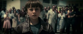 Movie still from “Green Lantern” (2011), directed by Martin Campbell – A young boy is standing in front of a group of people; Close Up shot, High angle