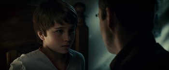 Movie still from “Green Lantern” (2011), directed by Martin Campbell – A young boy looking at a man in the dark; Close Up shot, Over the shoulder angle