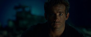 Movie still from “Green Lantern” (2011), directed by Martin Campbell – A man's face in a dark room; Close Up shot, Over the shoulder angle