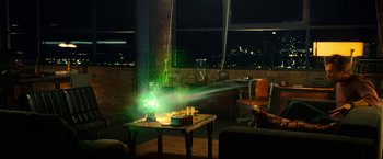 Movie still from “Green Lantern” (2011), directed by Martin Campbell – A table with candles and a green lamp on top of it in front of a large window; Wide shot, High angle