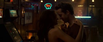 Movie still from “Green Lantern” (2011), directed by Martin Campbell – A man and a woman embracing in front of a neon sign; Close Up shot, Over the shoulder angle